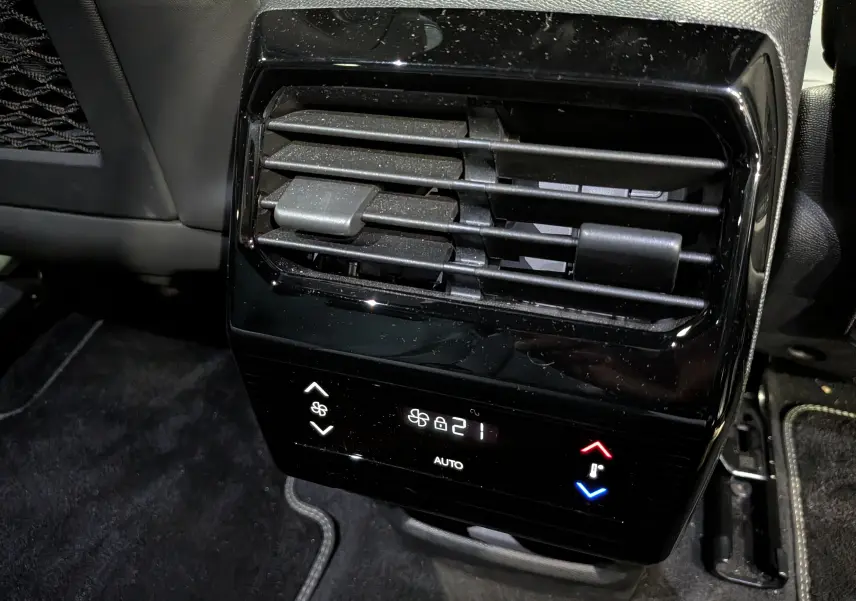 Détail de la console arrière de climatisation du Peugeot 5008 Hybrid 145 GT, avec commandes digitales et sorties d’air noires.