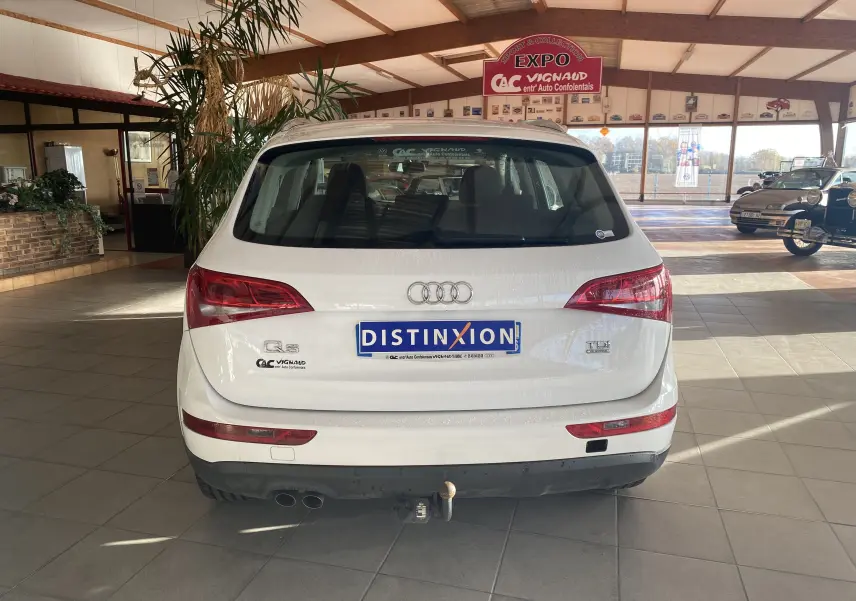Vue arrière d'un Audi Q5 blanc de 2012 avec attelage et feux arrière LED dans un showroom lumineux.