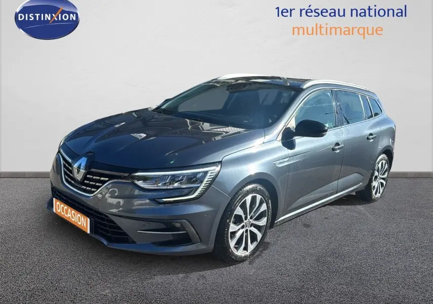 Renault Mégane Break gris titanium métal en 3/4 avant droit, avec jantes alliage et calandre distinctive.