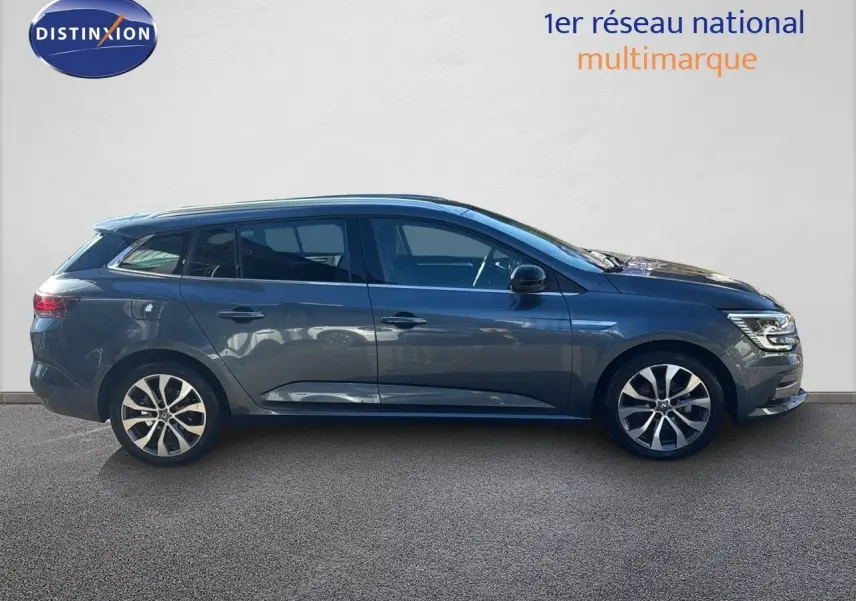 Profil droit de la Renault Mégane Break 1.5 BlueDCI 115ch gris titanium métal avec jantes bi-ton et feux LED allumés.