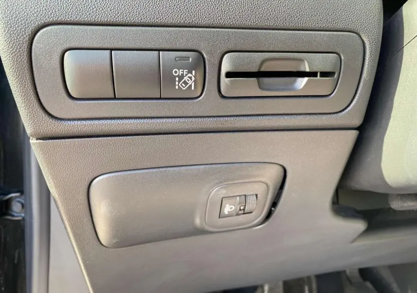 Vue rapprochée des commandes d'assistance et réglage des projecteurs côté conducteur du Citroën C3 Aircross noir 2023.