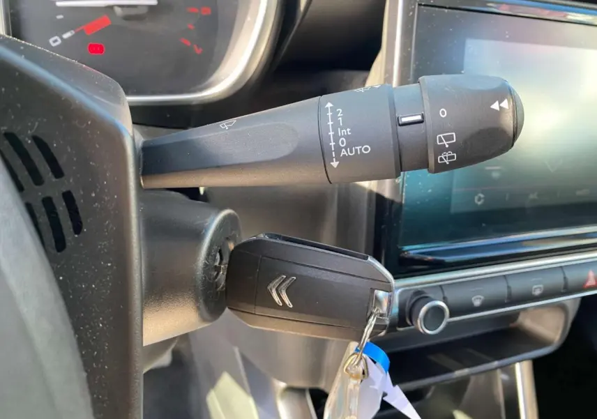Gros plan sur la clé de contact et le commodo d'essuie-glace du tableau de bord d'une Citroën C3 Aircross 2023.