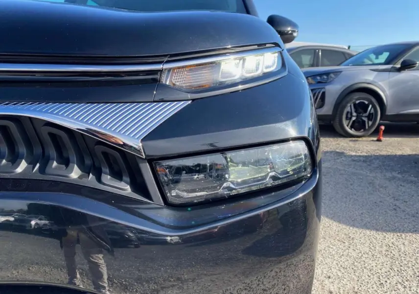 Gros plan sur l'avant droit du Citroën C3 Aircross noir 2023, mettant en valeur ses phares LED et la calandre chromée.