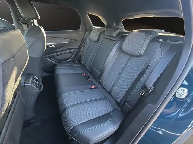 Vue intérieure du siège arrière droit du Peugeot 3008 bleu Celebes 2023, avec sellerie tissu et cuir noir contrasté.