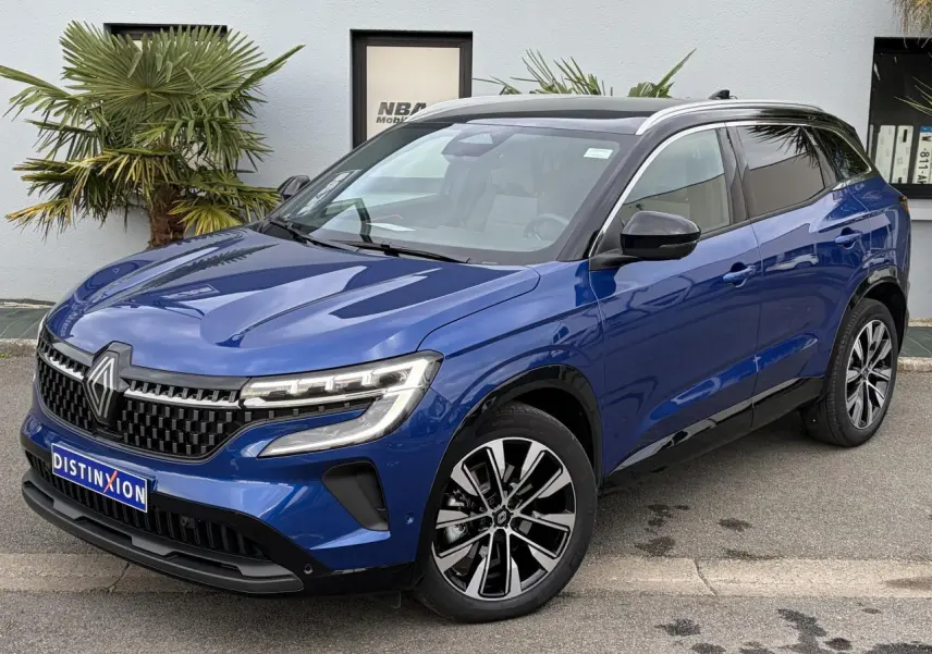 Renault Austral E-Tech hybride bleu Iron vue 3/4 avant droit avec toit panoramique noir et jantes alliage noires.