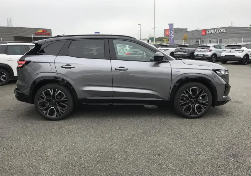 Profil droit du Renault Austral gris métallisé avec toit noir, jantes alliage noires et détails Esprit Alpine visibles.