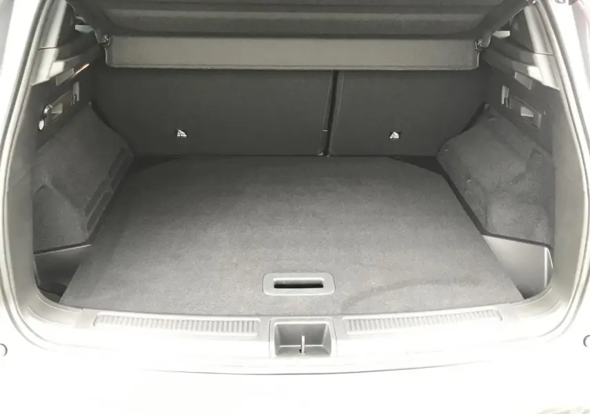 Coffre ouvert vu de l'arrière du Renault Austral gris, montrant le plancher plat et le revêtement intérieur sombre.