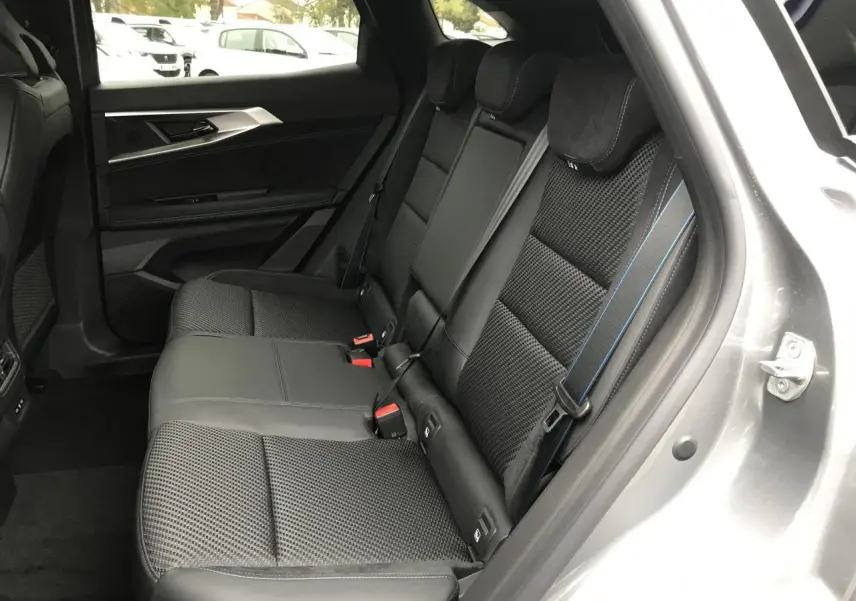 Vue intérieure côté droit sur la banquette arrière gris foncé avec surpiqûres bleues du Renault Austral 2025 bi-ton.