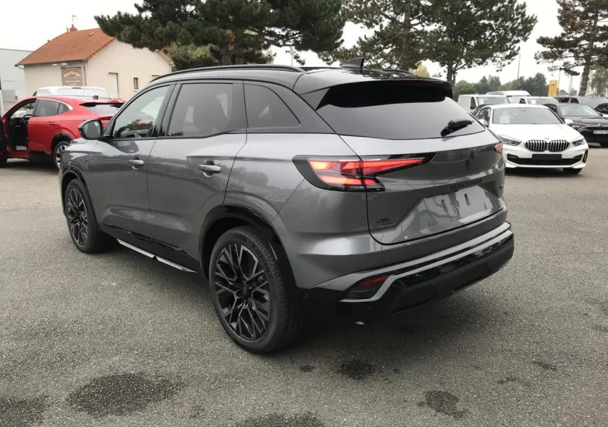 Vue 3/4 arrière d'un Renault Austral gris métallisé avec toit noir et jantes alliage noires diamantées.