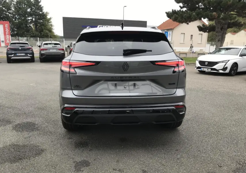 Vue arrière d’un Renault Austral gris bi-ton avec feux LED fins et hayon motorisé sur parking extérieur.