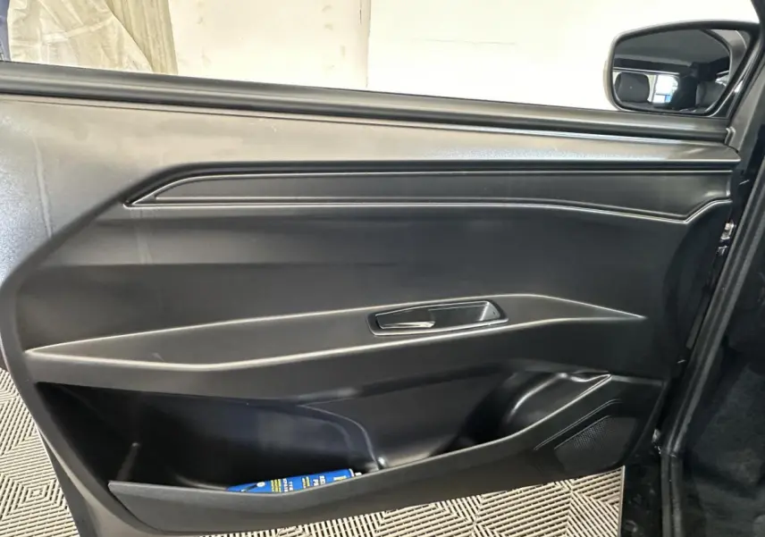 Vue intérieure sur la porte conducteur noire de l'AIXAM MINAUTO E ACCESS 2026 avec rétroviseur caméra côté gauche visible.