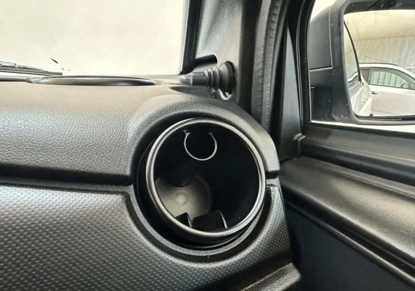 Détail de la sortie d'air circulaire côté conducteur de l'AIXAM MINAUTO E ACCESS 2026 blanc, avec rétroviseur extérieur caméra.