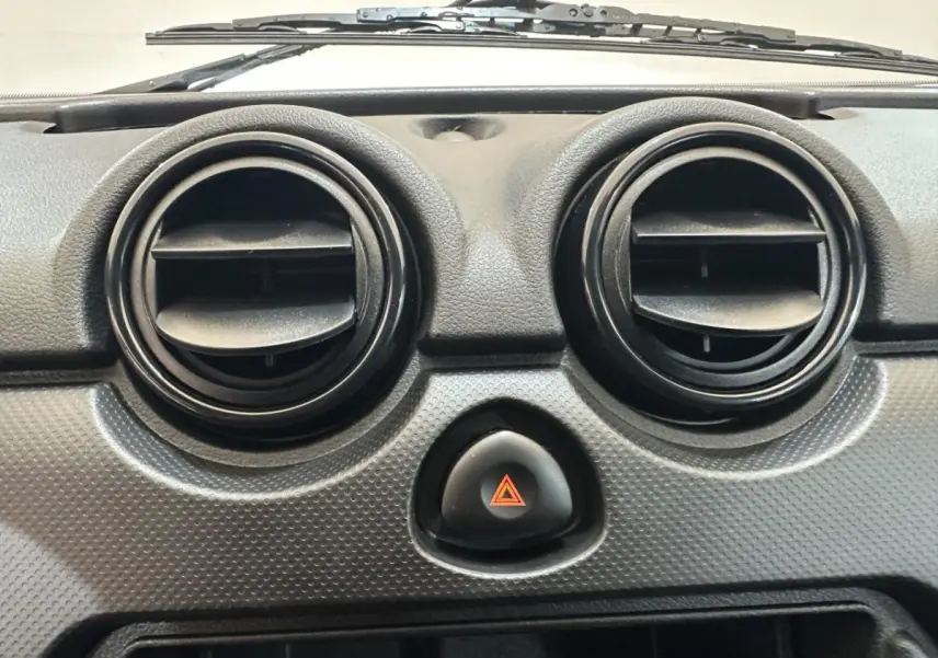 Détail du tableau de bord de l'AIXAM MINAUTO E ACCESS 2026 montrant les deux aérateurs ronds noirs et le bouton de warning central.