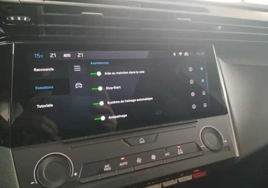Écran tactile central affichant les assistances à la conduite dans l’habitacle d’une Peugeot 308 SW gris Artense.