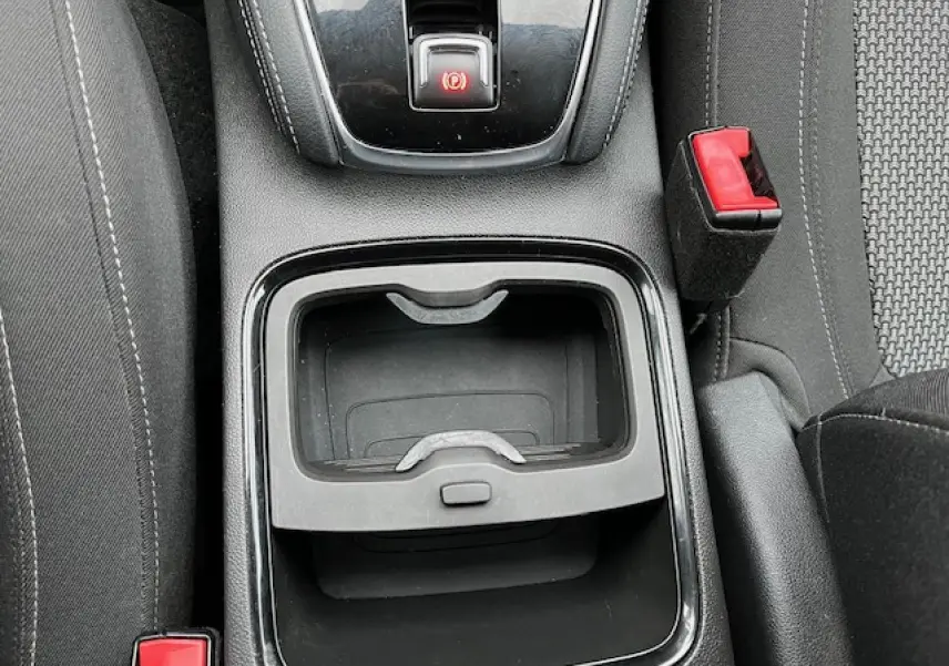 Vue plongeante sur la console centrale de l’Opel Grandland X gris, avec frein à main et rangement vide visible.