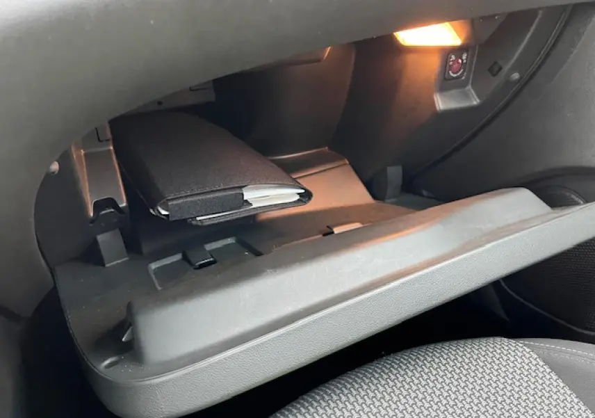 Intérieur de la boîte à gants ouverte de l’Opel Grandland X 2020, éclairage intérieur et livret visible.