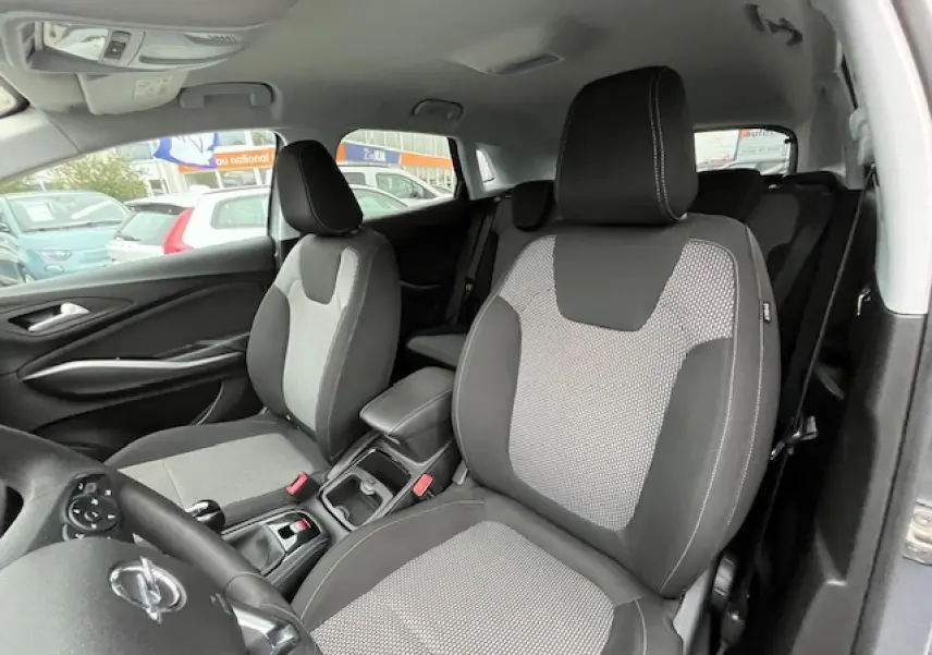 Vue intérieure avant droite de l’Opel Grandland X gris 2020, sièges tissu bicolore avec coutures contrastées.