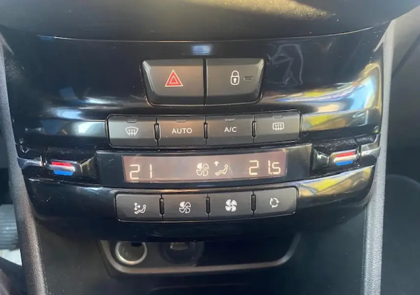 Vue rapprochée du tableau de bord noir du Peugeot 2008 2019, montrant les commandes de la climatisation automatique bi-zone.