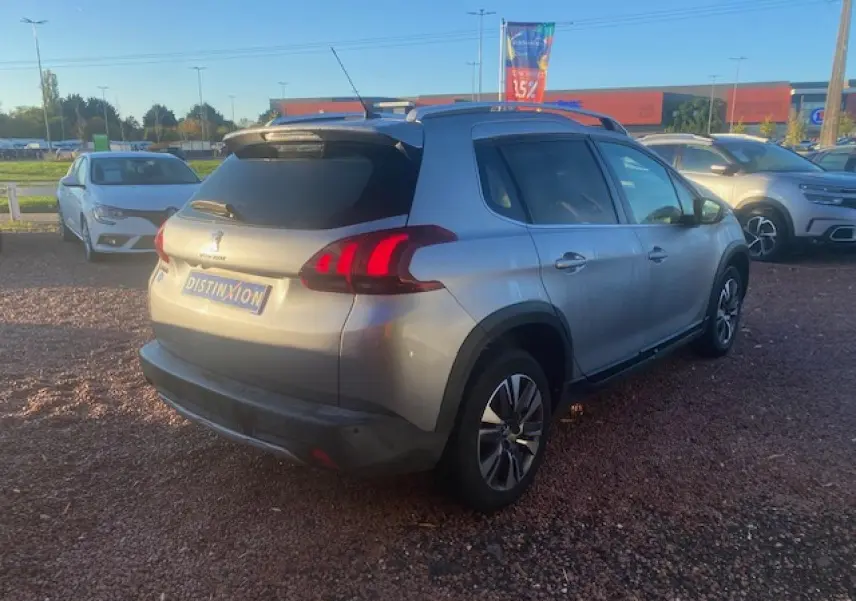Peugeot 2008 gris Artense vue 3/4 arrière droit, jantes aluminium 16 pouces et vitres arrière surteintées.
