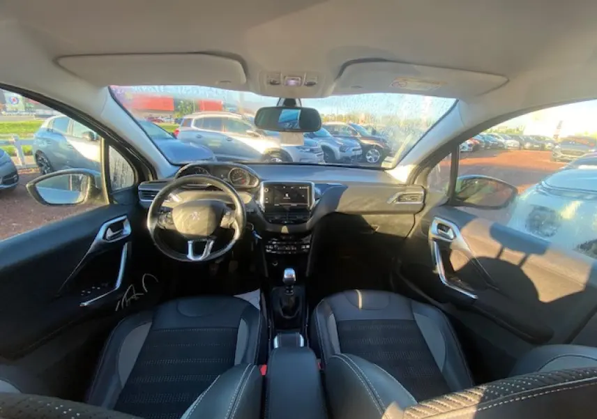 Vue intérieure avant de la Peugeot 2008 gris Artense 2019, avec tableau de bord moderne et volant multifonctions.