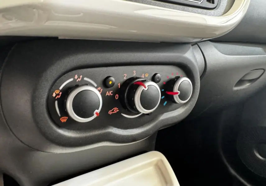 Gros plan sur les commandes de climatisation noires et grises de la Renault Twingo gris foncé, version Intense Energy TCe 90.