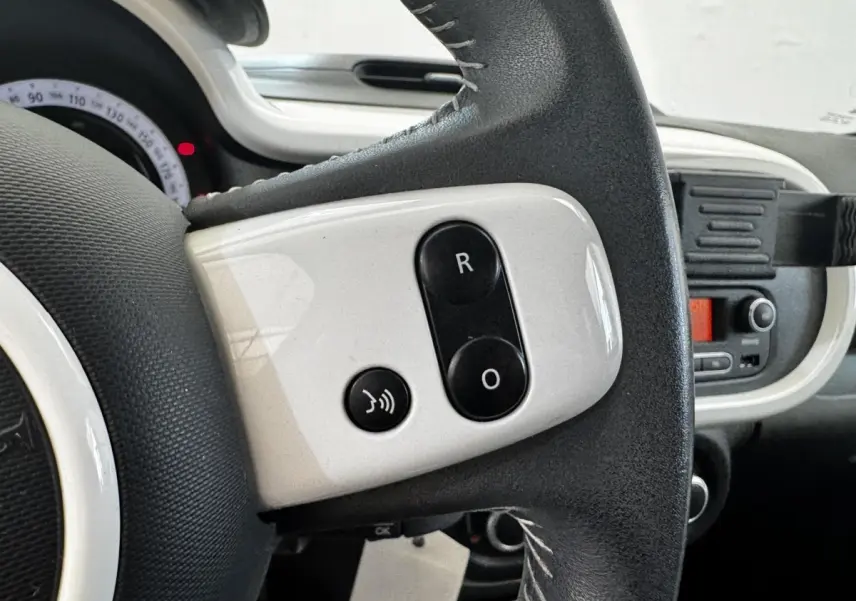 Gros plan sur le volant cuir noir et blanc avec commandes vocales de la Renault Twingo Intense Energy TCe 90 gris foncé, 2016.