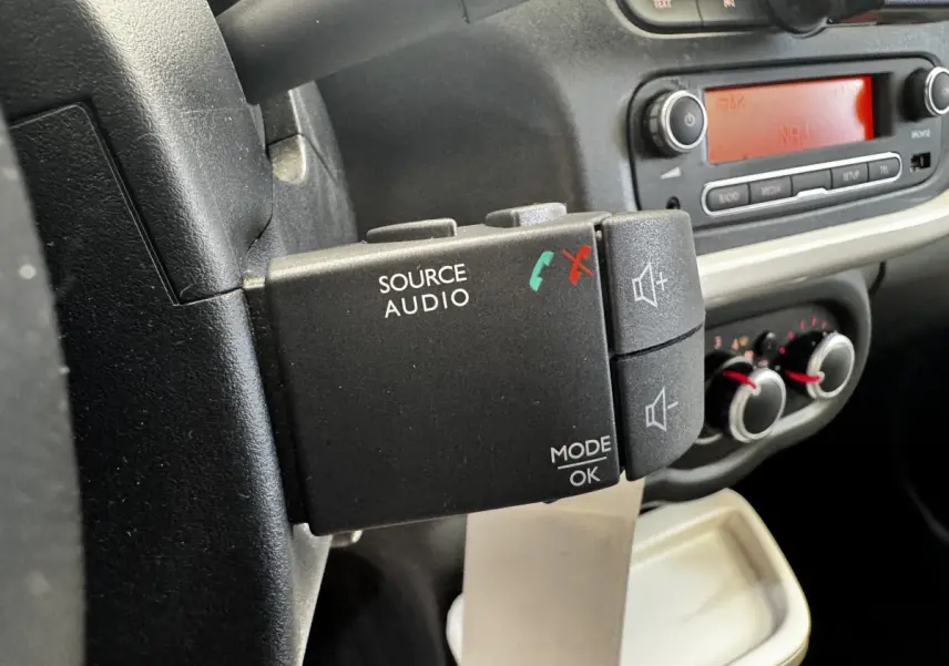 Gros plan sur la commande audio au volant côté gauche dans l’habitacle gris foncé de la Renault Twingo Intense Energy 2016.