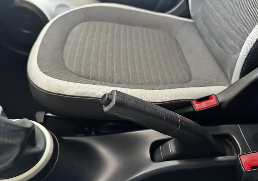 Gros plan sur le frein à main et siège avant gris clair et foncé de la Renault Twingo Intense Energy TCe 90 de 2016.