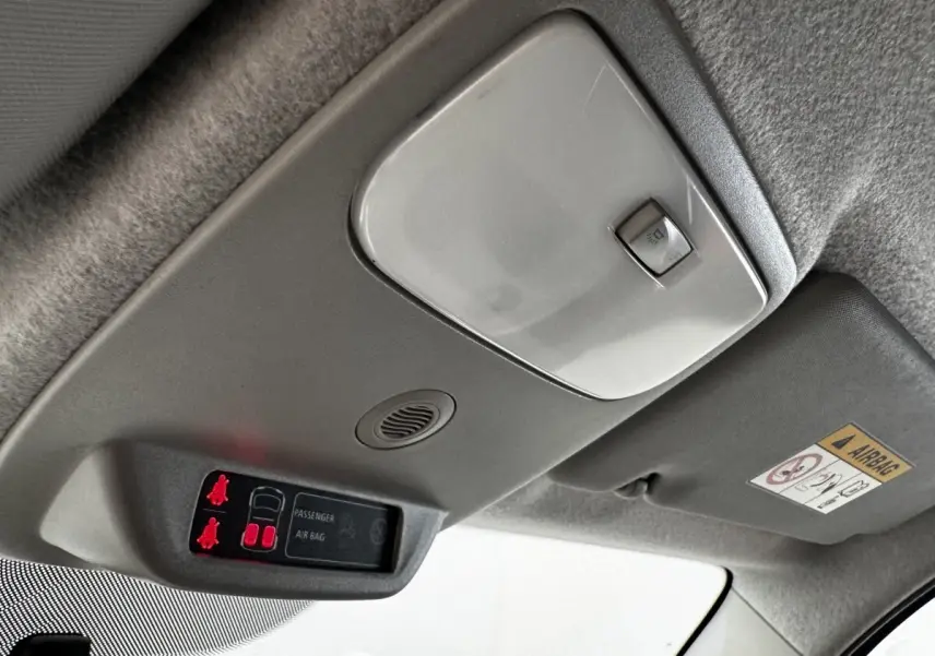 Détail du plafonnier gris clair avec éclairage et indicateurs de ceinture et airbag dans une Renault Twingo 2016.