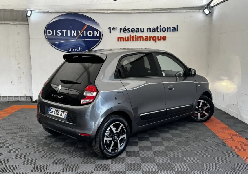 Renault Twingo gris foncé vue 3/4 arrière droit, avec toit noir et jantes alliage bicolores.