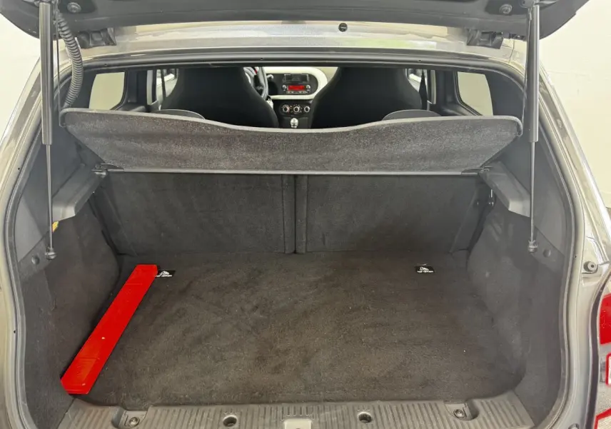 Vue arrière du coffre ouvert d'une Renault Twingo gris foncé, avec banquette arrière et intérieur visible.