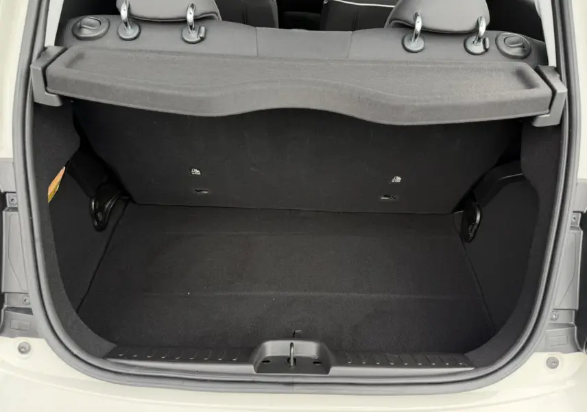 Coffre ouvert vu de l'arrière d'une FIAT 500 électrique blanc Artic, montrant l'espace de rangement intérieur noir.