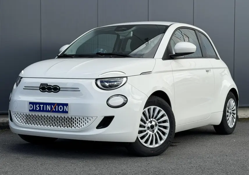 Vue 3/4 avant droite d'une FIAT 500 électrique blanche Arctic avec jantes multibranches et logo noir sur calandre.