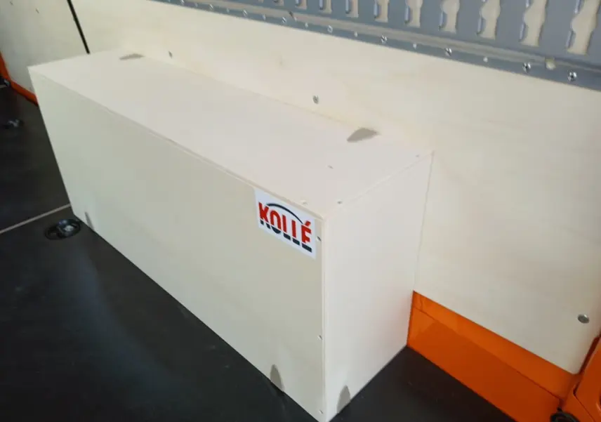 Détail intérieur montrant un coffre en bois clair fixé sur la paroi orange du Renault Master L2H2 2026.