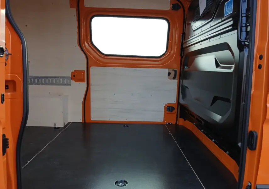 Vue intérieure arrière du Renault Master orange L2H2, montrant l'espace de chargement avec parois en bois clair.