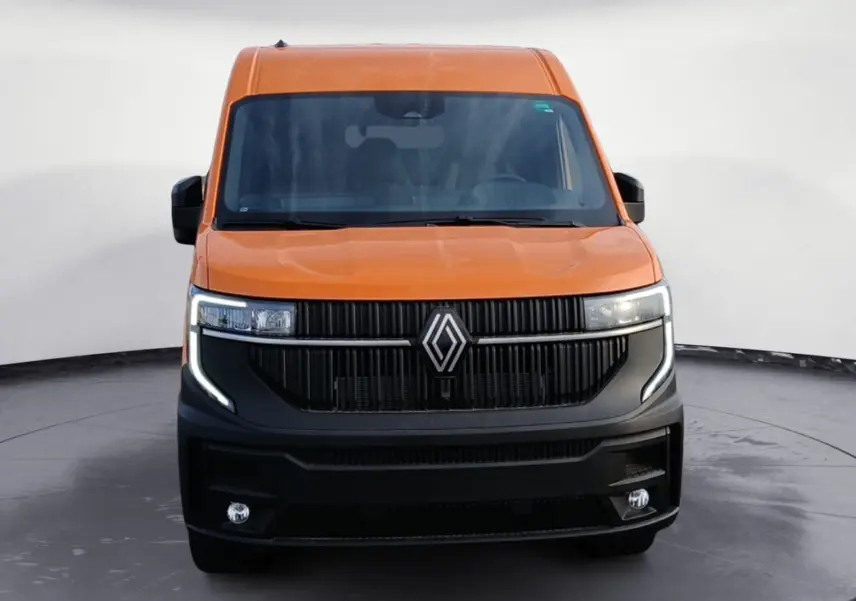 Vue frontale d’un Renault Master L2H2 orange avec calandre noire et feux LED en forme de C.