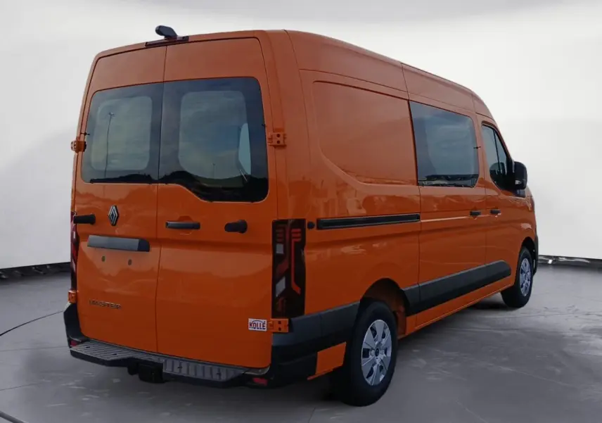 Vue 3/4 arrière droite d’un Renault Master orange avec vitres arrière et latérales, marchepied et feux arrière verticaux.
