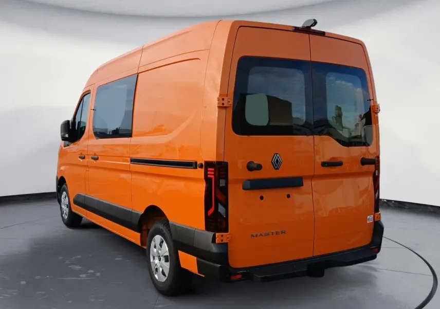 Vue 3/4 arrière droite du Renault Master orange, avec vitres arrière teintées et feux arrière LED distinctifs.