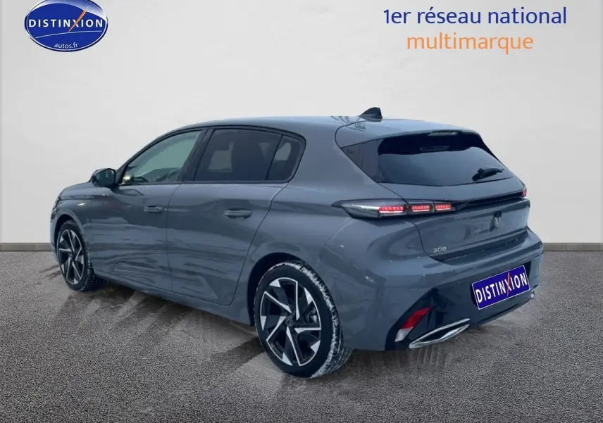 Vue 3/4 arrière droite d'une Peugeot 308 gris sélénite avec jantes alu et feux arrière LED allumés.