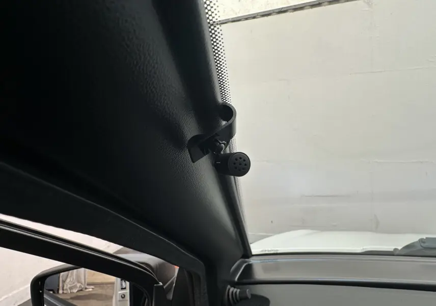 Vue intérieure côté conducteur montrant la caméra intégrée au rétroviseur extérieur d'une Aixam Ambition E City Pack blanche.