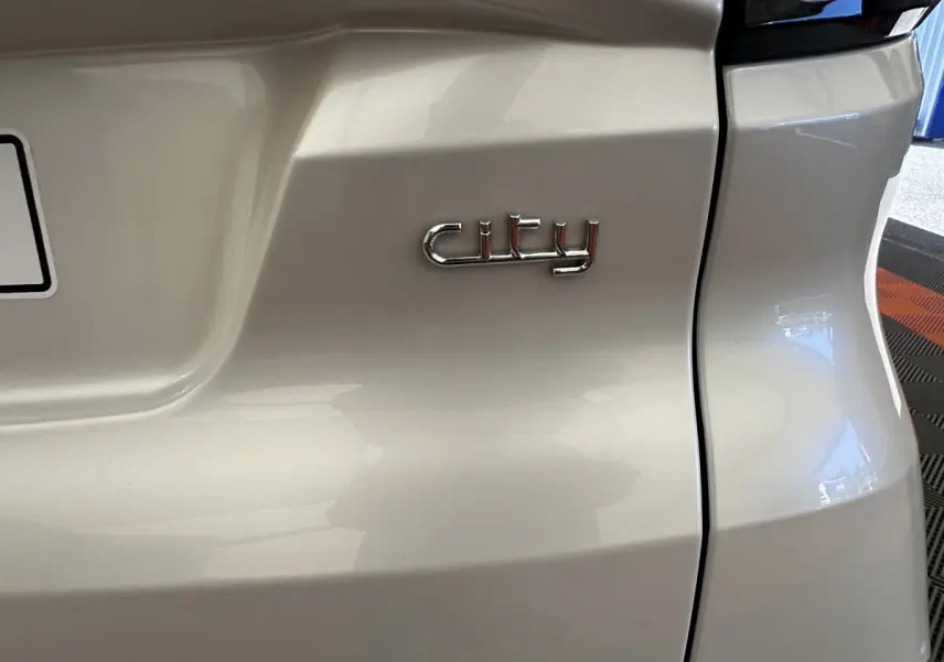 Gros plan sur l'arrière blanc d'une Aixam Ambition E City Pack 2026 avec l'inscription "city" en chrome.