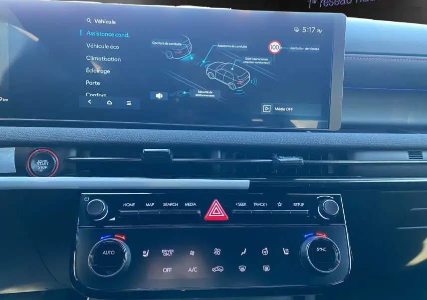 Vue intérieure du tableau de bord du Hyundai Tucson 2025, avec écran tactile et commandes climatisation en noir.