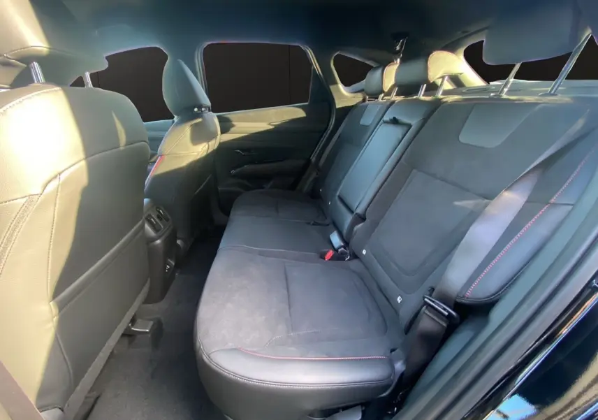 Vue intérieure arrière côté droit du Hyundai Tucson 2025 noir abyss avec sièges en cuir noir et surpiqûres rouges.