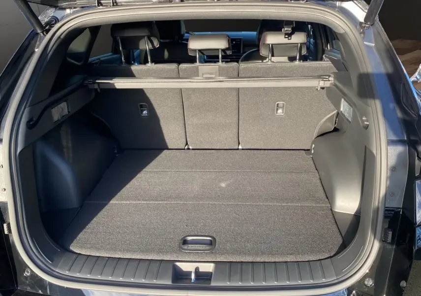 Coffre ouvert vu de l'arrière d'un Hyundai Tucson 2025 noir abyss, montrant un espace de chargement spacieux et bien fini.