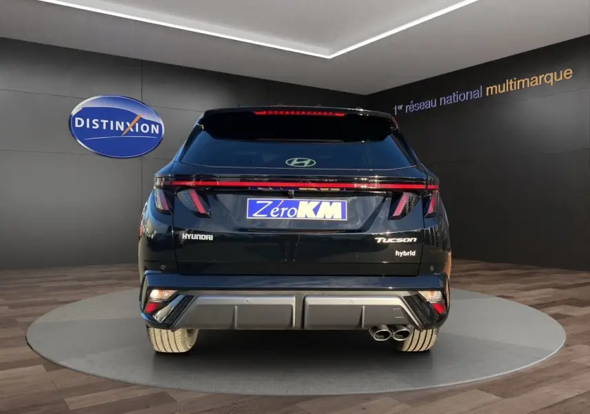 Vue arrière du Hyundai Tucson 1.6 T-GDI hybride noir Abyss, avec feux LED et double sortie d'échappement visible.