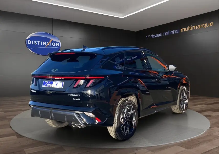 Vue 3/4 arrière droite du Hyundai Tucson 2025 en noir abyss, avec feux arrière LED et jantes alliage distinctives.