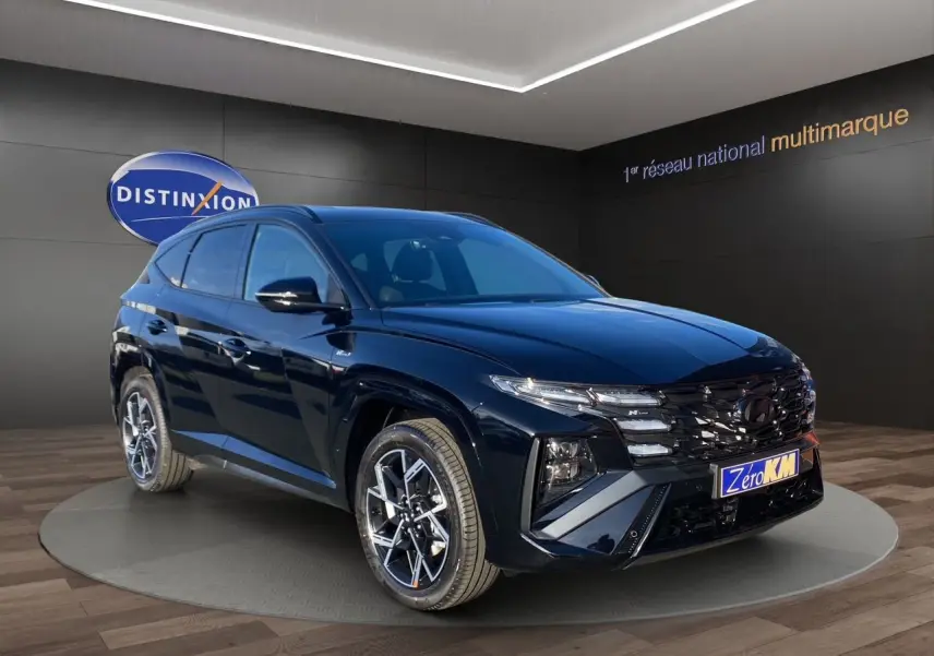 Hyundai Tucson 2025 hybride noir abyss, vue 3/4 avant droit, avec jantes alliage et calandre distinctive N Line.