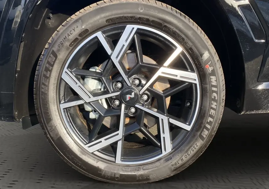 Gros plan sur la jante alliage noire et argentée avec logo N du Hyundai Tucson 2025 couleur Abyss Black.