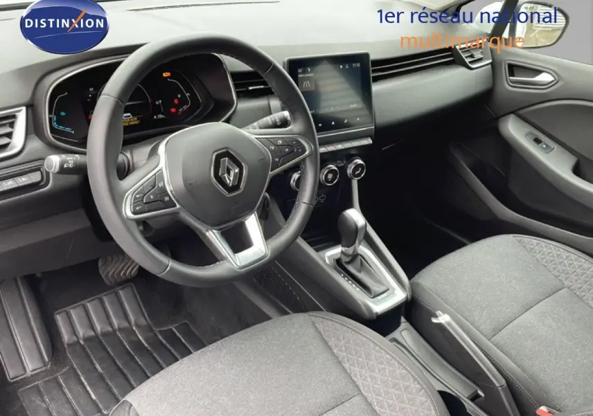 Vue intérieure centrée sur le volant et la console centrale d'une Renault Clio 2020, sièges tissu gris et tableau de bord noir.
