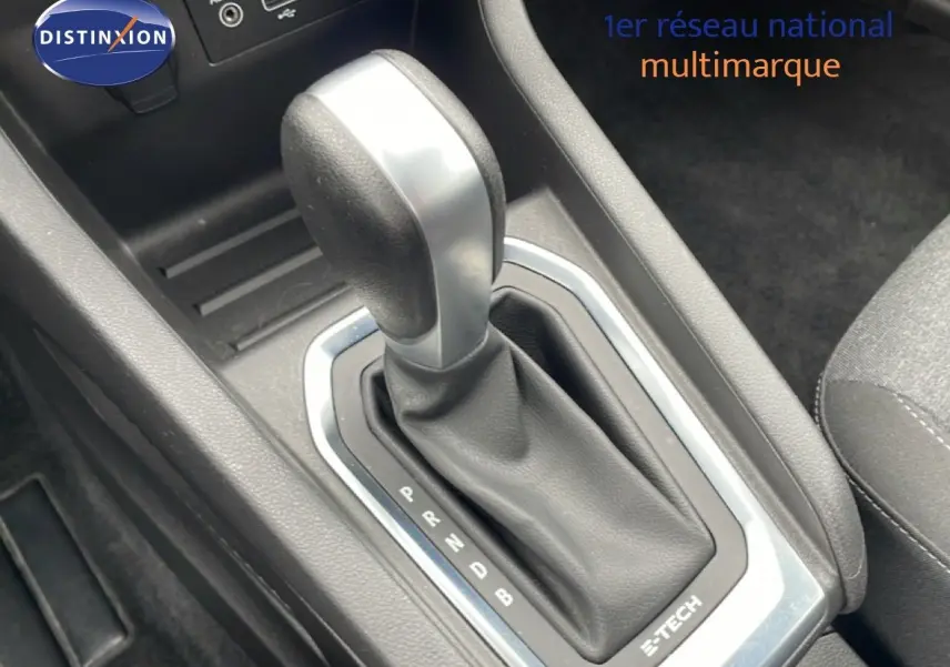 Gros plan sur la commande de boîte automatique de la Renault Clio V 1.6 E-TECH blanche, avec levier en cuir noir.